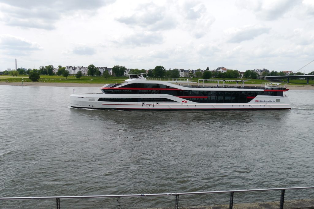 Ein weißes Ausflugsschiff schwimmt auf dem Rhein.