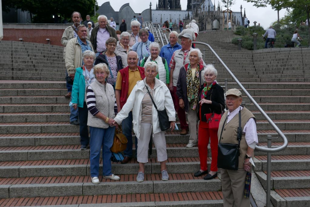 Die Teilnehmer der Tagestour stehen für ein Gruppenbild auf einer Treppe und schauen in die Kamera.